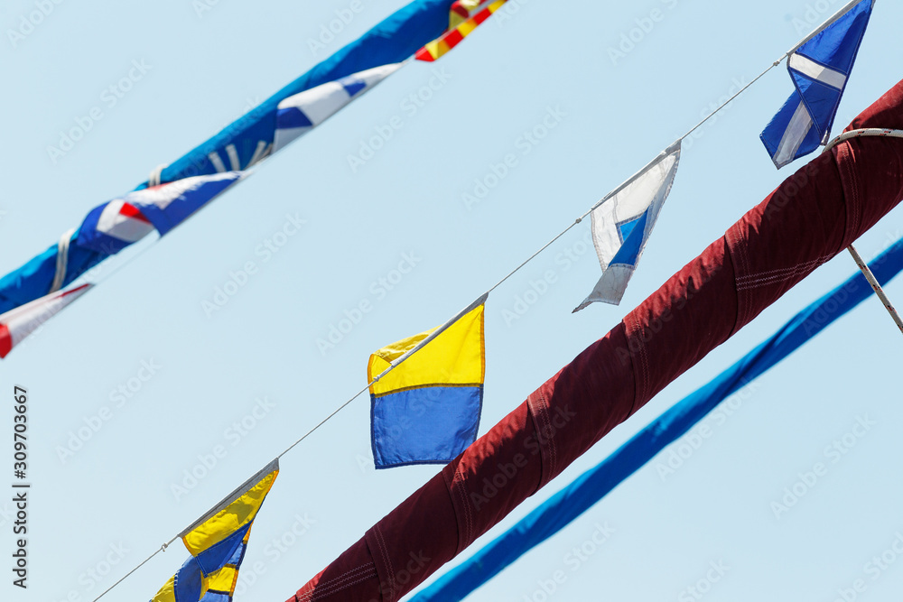 Obraz premium Sea holiday flags are pulled over the yards of a snow-white yacht
