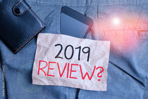 Writing note showing 2019 Review Question. Business concept for remembering past year events main actions or good shows Smartphone device inside trousers front pocket with wallet