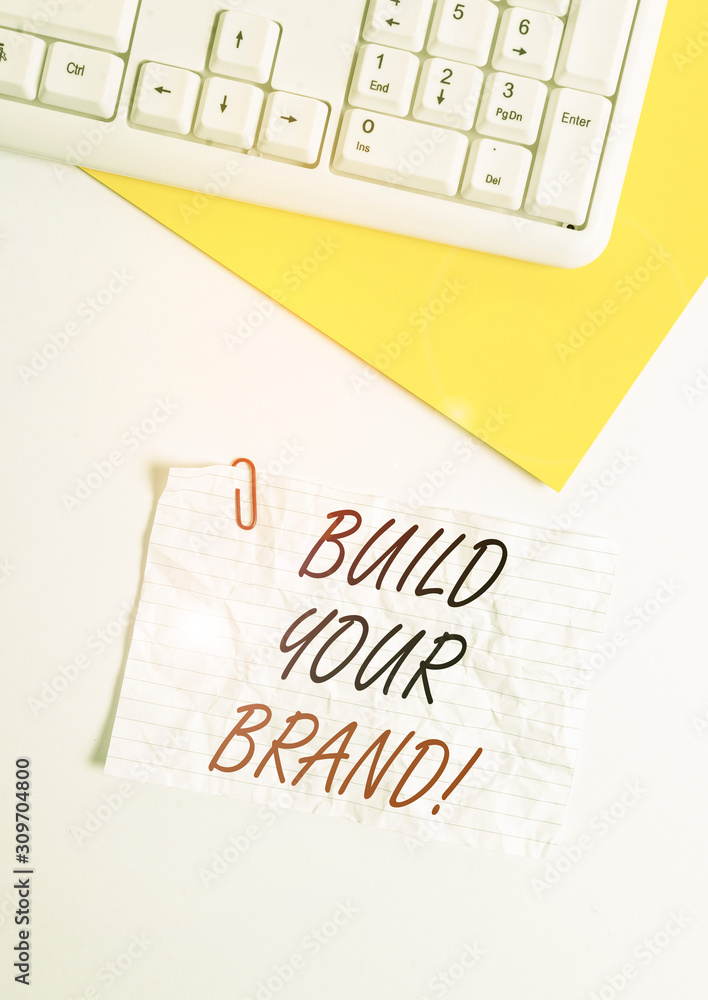 Text sign showing Build Your Brand. Business photo showcasing creates or improves customers knowledge and opinions of product Flat lay above white blank paper with copy space for text messages Text sign showing Build Your Brand. Business photo showcasing creates or improves customers knowledge and opinions of product Flat lay above white blank paper with copy space for text messages