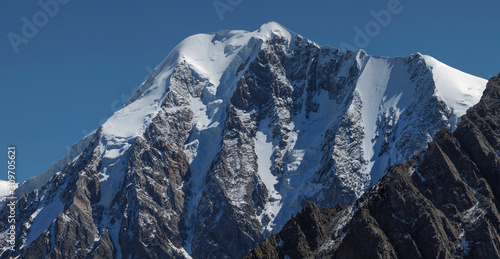 Picturesque mountain peak. Snow, glaciers and steep rocky slopes. Traveling in the mountains, climbing.