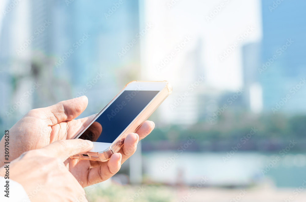5G technology world wide web connecting. close up business man using hand typing smartphones and touch screen working search with app devices outdoor in city with sunrise and building background.