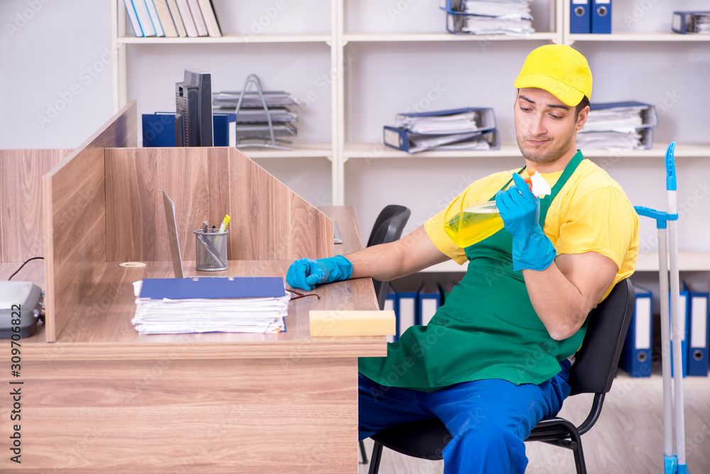 Young male contractor cleaning the office Young male contractor cleaning the office