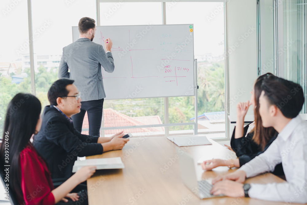 Young businessmen are explaining graphs and statistics on a whiteboard. The managers and employees of the company attending the meeting. Young businessmen are explaining graphs and statistics on a whiteboard. The managers and employees of the company attending the meeting.