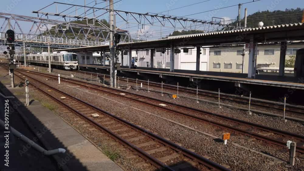 Train station in Japan, Warm afternoon on empty platform as train arrives at Maibara Station Train station in Japan, Warm afternoon on empty platform as train arrives at Maibara Station