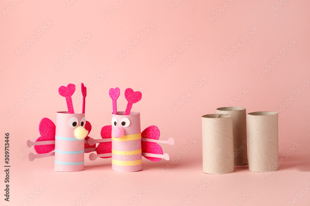 Paper toy butterfly for valentine romance baby shower, birthday party. Easy crafts for kids on pink background, copy space, die creative idea from toilet tube roll, recycle reuse eco Paper toy butterfly for valentine romance baby shower, birthday party. Easy crafts for kids on pink background, copy space, die creative idea from toilet tube roll, recycle reuse eco