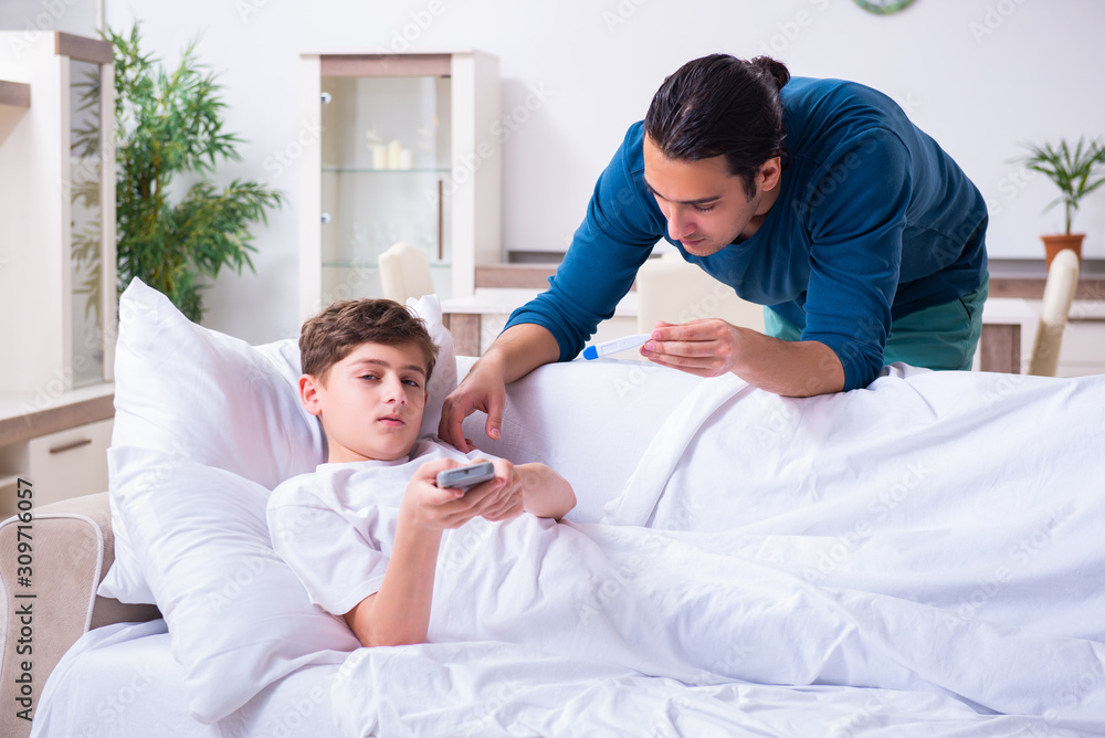 Fototapeta premium Young father caring for sick son
