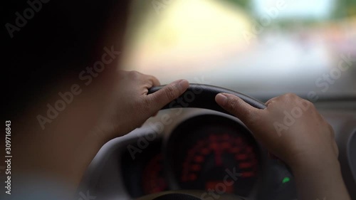 man driving car in day time through tunnel, hand on steering wheel, shallow depth of field.