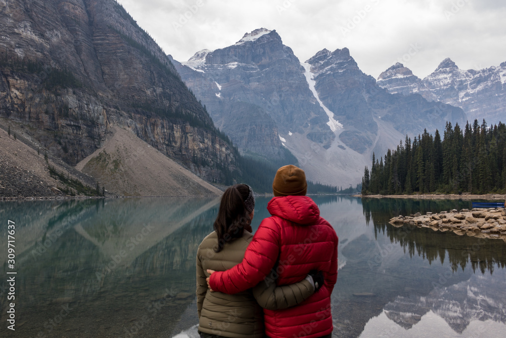 couple looking out over a lake in the mountains couple looking out over a lake in the mountains