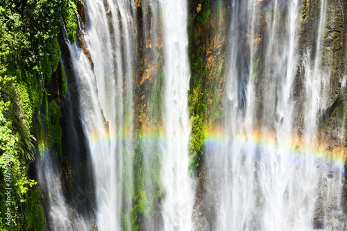 View from above, stunning view of the Tumpak Sewu Waterfalls also known as Coban Sewu with a beautiful rainbow formed by refraction of light in water droplets. East Java, Indonesia.