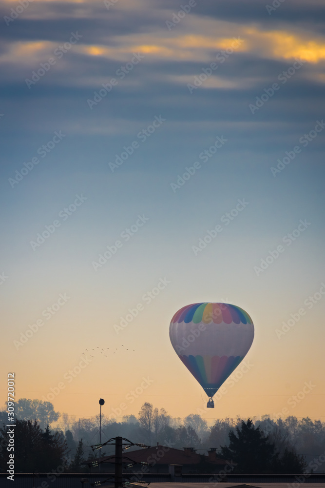 hot air balloon that furs the sky during a clear sunrise