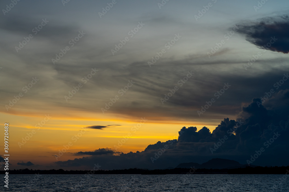 Sunset background and sun beam on the open sea with beautiful clouds.