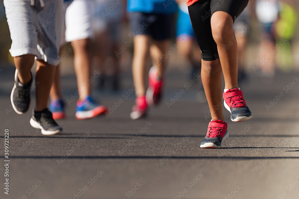 Running children, young athletes run in a kids run race,running on city road detail on legs