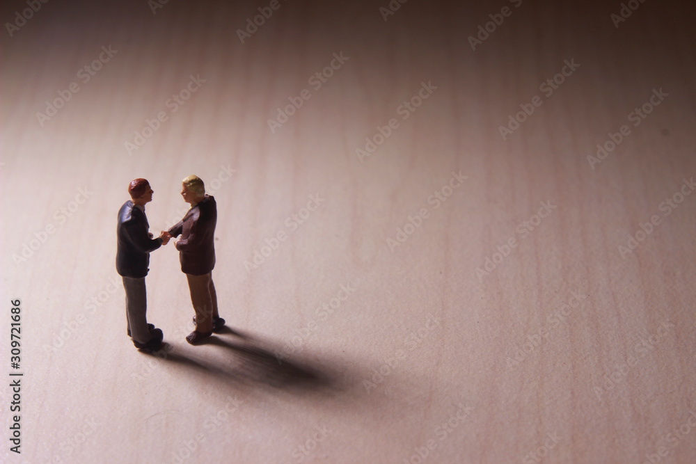 Dramatic Lighting, Simple Illustration Photo for Two Mini Figure Businesman Toy Handshaking for Business Agreement Dramatic Lighting, Simple Illustration Photo for Two Mini Figure Businesman Toy Handshaking for Business Agreement
