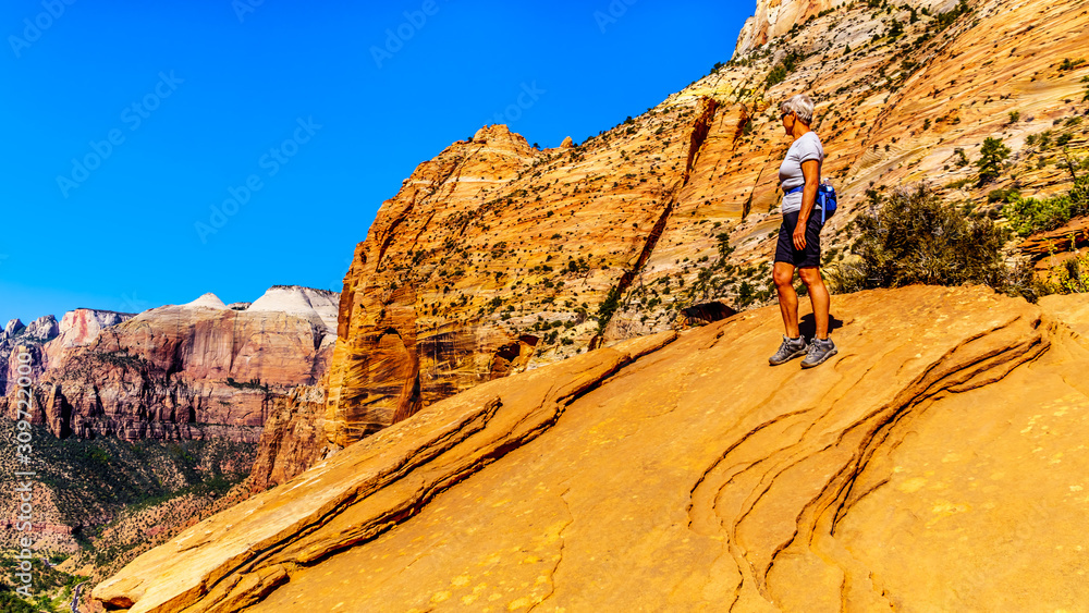 Active Senior Woman looking into Zion Canyon from the top of the Canyon Overlook Trail in Zion National Park, Utah, United States