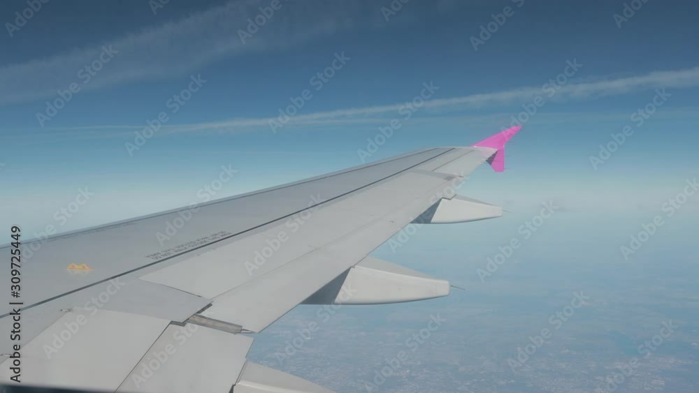 Spectacular view with clouds on ground with city, houses from airplane illuminator. Flying by plane, high altitude, wing of aircraft. Horizon cannot be seen.