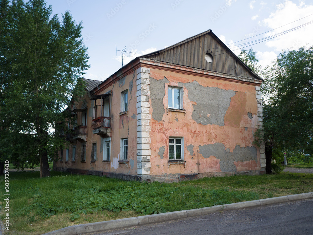 Old dilapidated two-story house. Retro city building