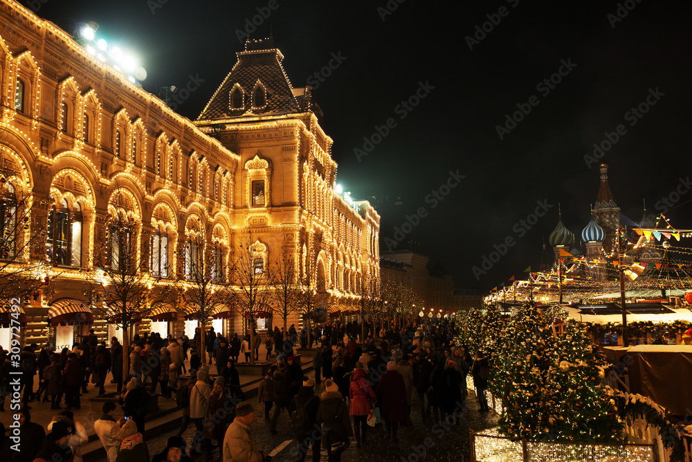 Obraz premium Celebration lights and decorations on Red Square for festive Christmas and New Year. Shining yellow lights on facade GUM in Moscow, Russia. Night cityscape of Moscow