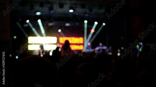 Celebration in holiday feast. Night music concert performance show of a musical group. Disco colorful illumination. Dancing youth fans and people crowd