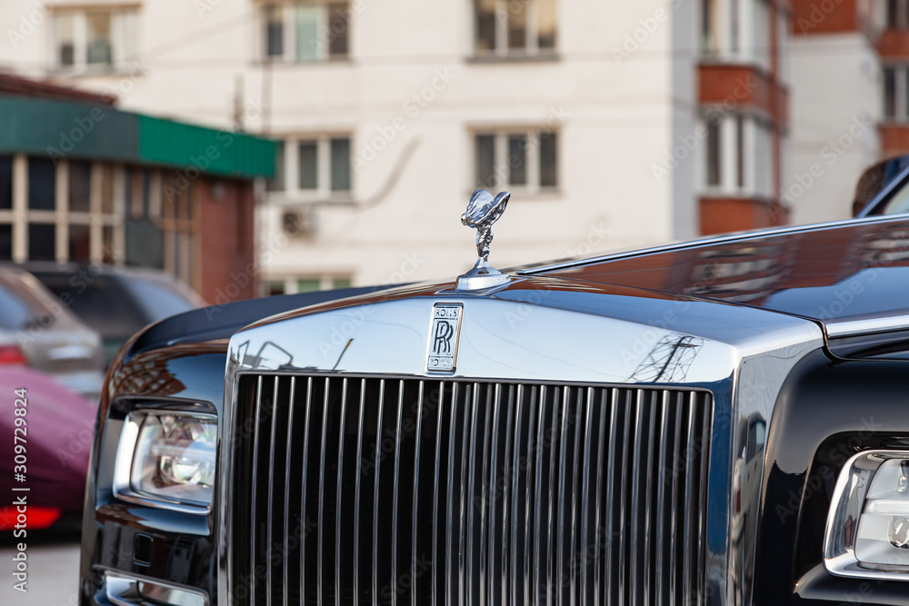 Front view of emblem Spirit of Ecstasy, grille and headlights of new a very  expensive Rolls Royce Phantom car, a long black limousine, model outdoors  on parking Stock Photo | Adobe Stock