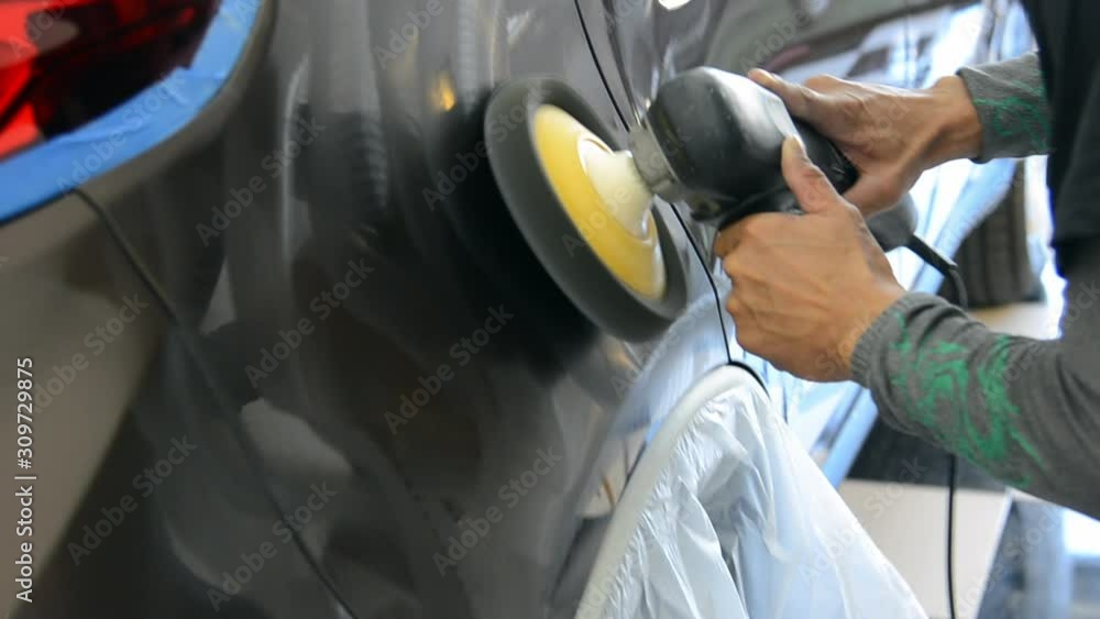 A man works at polishing the car after washing the car. Car polishing ...