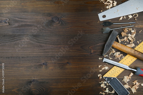 different carpentry tools and wood shavings on wooden background with copy space