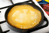 rosy pancake fried in a pan on a stove