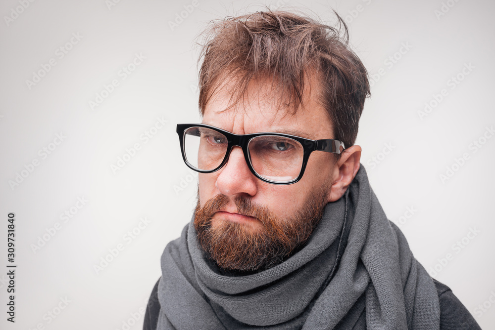 Portrait of a gloomy sick young man. Neutral light background. Portrait of a gloomy sick young man. Neutral light background.