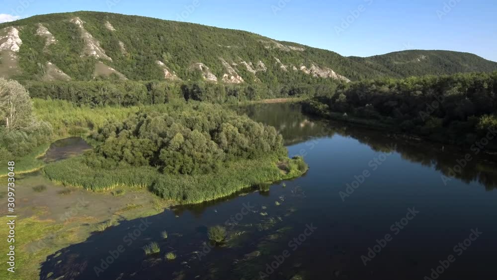 The remain of the reef of the ancient sea, composed of limestone - shikhan Kushtau on a summer day. The main river of Bashkiria - Belaya. Aerial view. The remain of the reef of the ancient sea, composed of limestone - shikhan Kushtau on a summer day. The main river of Bashkiria - Belaya. Aerial view.