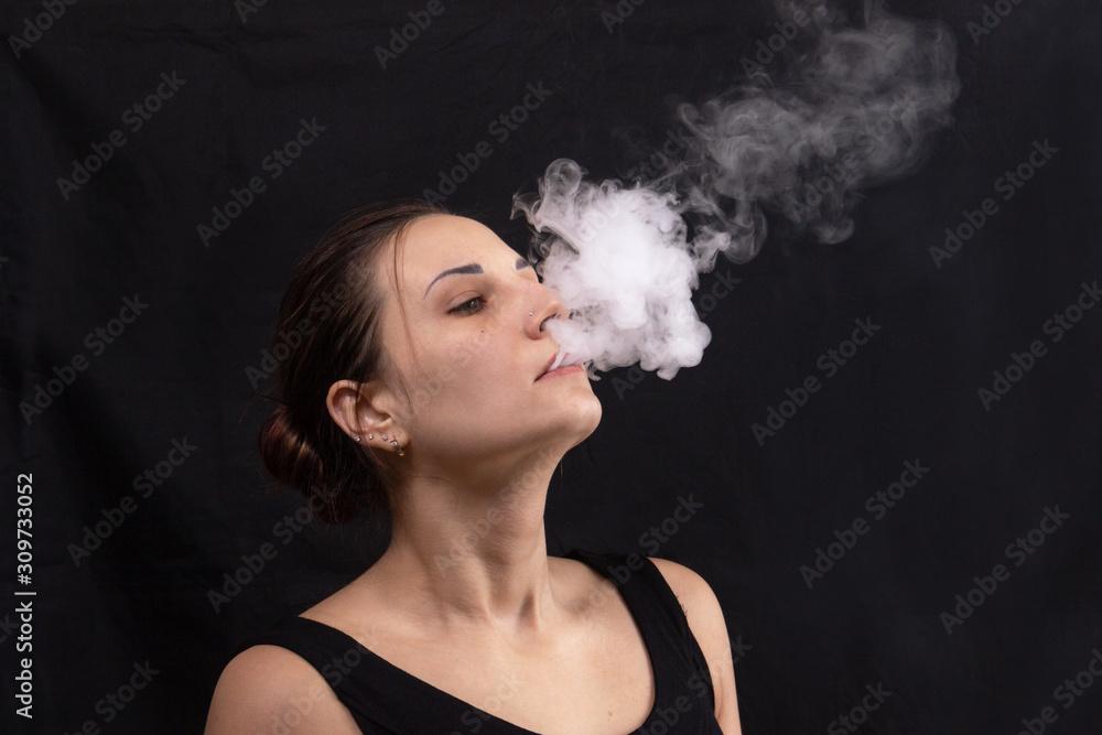 Portrait of girl blowing smoke water vapor from vape