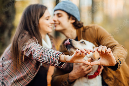 Love story couple in love enjoying their time with labrador in outumn park nature. photo