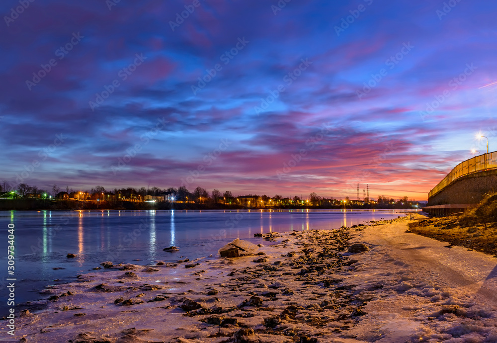 Fototapeta premium Bright December dawn on the Neva river in Rybatskoye district in