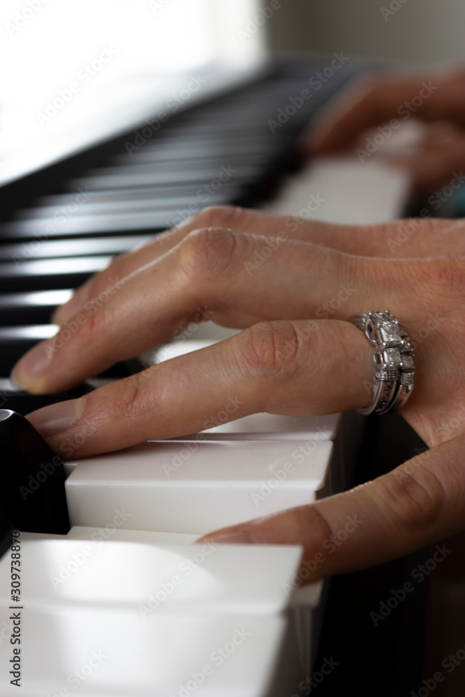 A Close-up of the Fingers of a Married Women Playing the Piano - Key Board - In Alaska. 