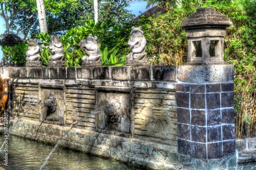 traditional balinese architecture and statues and fountains in a garden setting