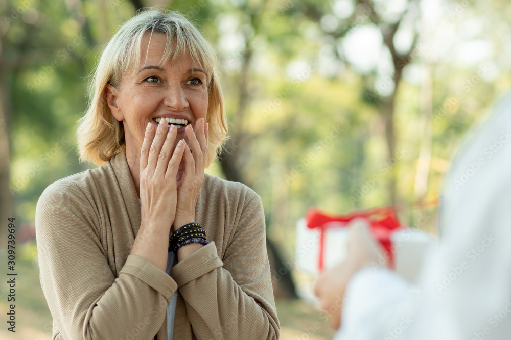 Beautiful elderly woman surprise with gift from husband in park, Take care and thank you of love concept Beautiful elderly woman surprise with gift from husband in park, Take care and thank you of love concept