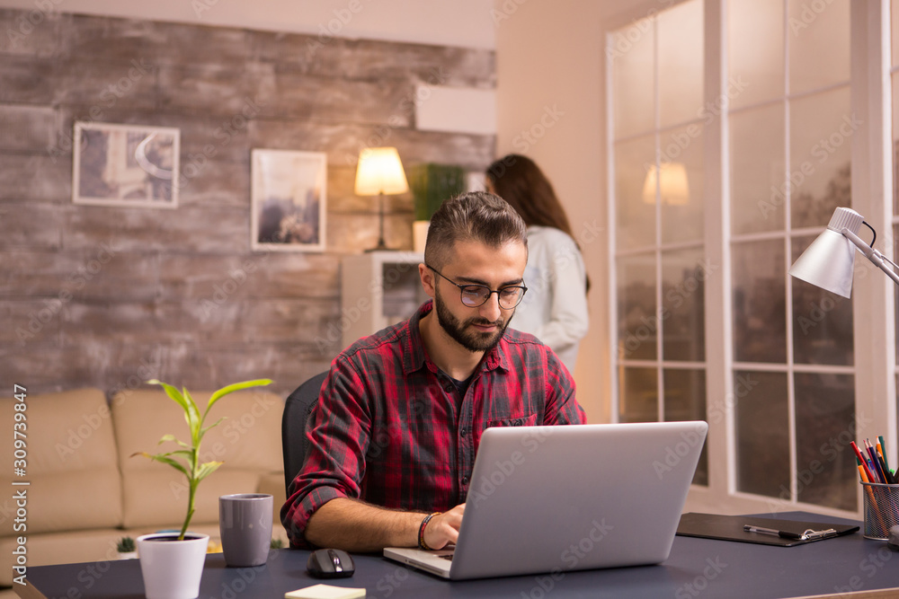 Bearded freelancer working typing on laptop from home Bearded freelancer working typing on laptop from home
