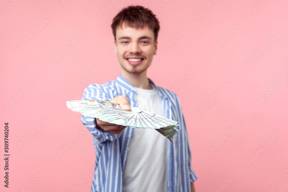 Portrait of successful rich brunette man with small beard and mustache in casual shirt proposing dollars to camera, giving big sun of money, investment. indoor studio shot isolated on pink background Portrait of successful rich brunette man with small beard and mustache in casual shirt proposing dollars to camera, giving big sun of money, investment. indoor studio shot isolated on pink background