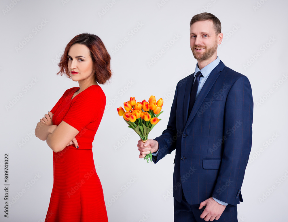 relationship and love concept - portrait of man with flowers and angry sad girl over white relationship and love concept - portrait of man with flowers and angry sad girl over white