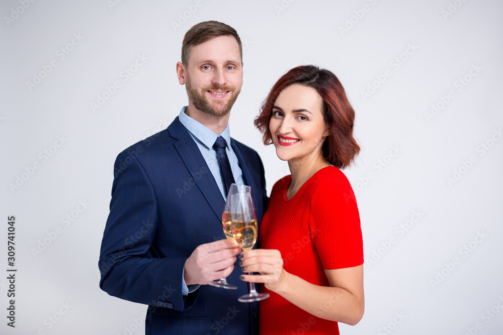 valentine's day, christmas and new year concept - portrait of beautiful couple posing with glasses of champagne over white valentine's day, christmas and new year concept - portrait of beautiful couple posing with glasses of champagne over white