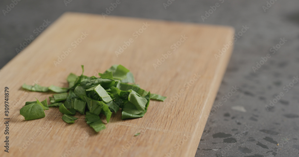 chopped fresh spinach leaves on oak cutting board chopped fresh spinach leaves on oak cutting board