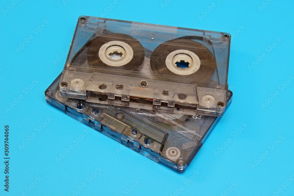Plastic transparent audio cassettes located on a blue background Plastic transparent audio cassettes located on a blue background