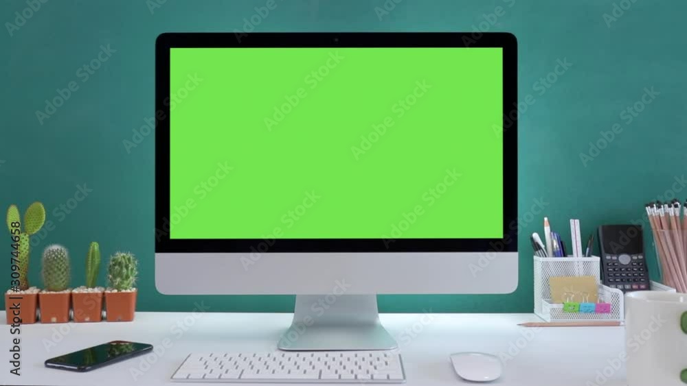 Computer desktop with mock-up green screen white background in office and Lovely cactus in brown pot , Zoom shoulder view. Computer desktop with mock-up green screen white background in office and Lovely cactus in brown pot , Zoom shoulder view.