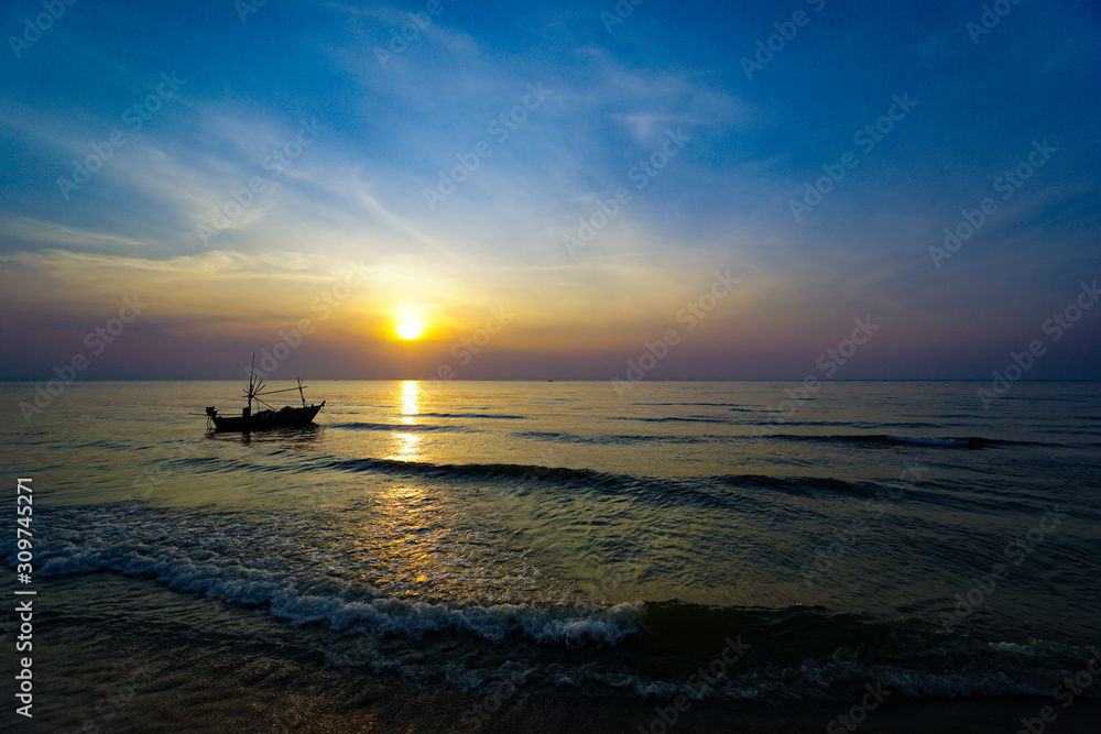 Colorful Sunrise with Sand and boat on the ocean at Huahin Thailand .