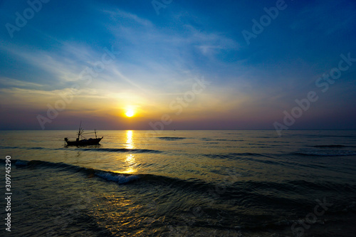 Colorful Sunrise with Sand and boat on the ocean at Huahin Thailand .