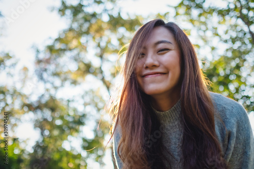 Obraz na plátně Portrait image of a beautiful asian woman standing among nature in the park