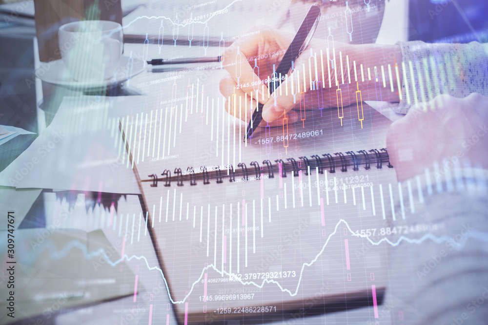 Hand taking notes in notepad. Forex chart holograms in front. Concept of research. Double exposure Hand taking notes in notepad. Forex chart holograms in front. Concept of research. Double exposure