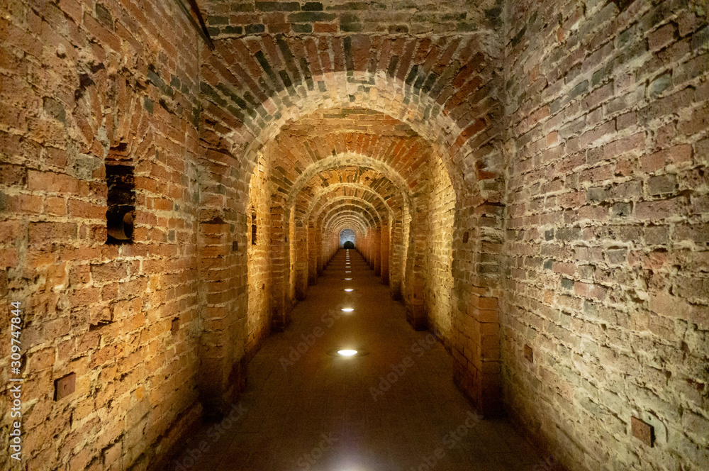 Brick archway made of red bricks as a passage between the two wings of a medieval castle. Granite stone an brick built Interior passage to bastions