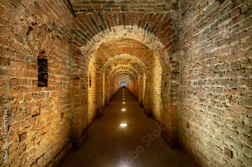 Brick archway made of red bricks as a passage between the two wings of a medieval castle. Granite stone an brick built Interior passage to bastions