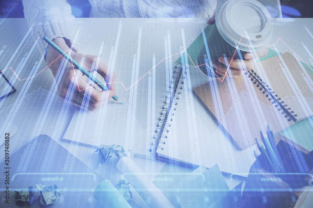 Financial forex graph displayed on hands taking notes background. Concept of research. Multi exposure Financial forex graph displayed on hands taking notes background. Concept of research. Multi exposure