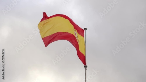 Yellow Red Spain Flag waving on a dramatic sky background. Slow motion photo