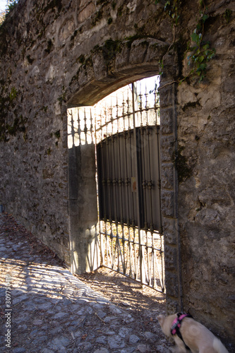 Cancello in ferro tra vecchie mura medievali rovinate in un borgo del lago di Como. photo
